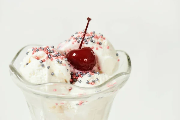 Közelkép a fehér vanília fagylalt csésze édes szemek és bing cseresznye tetején elszigetelt fehér alapon — Stock Fotó