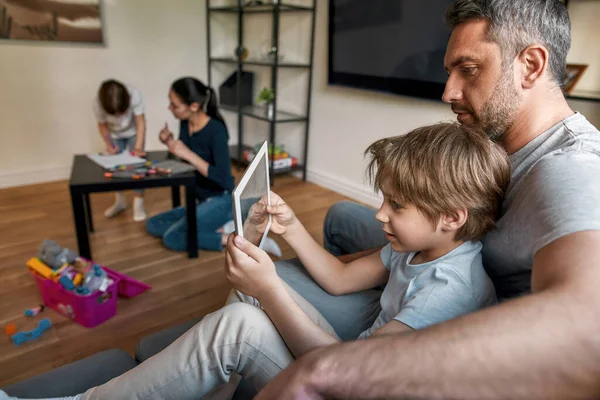 Kavkazský otec hrát tablet s malým synem doma — Stock fotografie