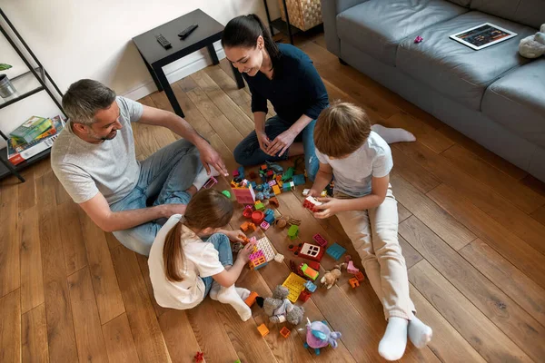 Gelukkig ouders hebben plezier spelen speelgoed met kinderen — Stockfoto