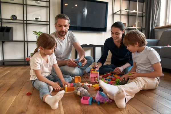 Loving parents play toys with small kids on weekend — Stock Photo, Image