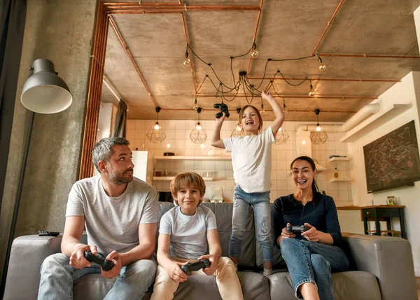 Χαρούμενα παιδιά παίζουν βιντεοπαιχνίδια με τους γονείς στο σπίτι — Φωτογραφία Αρχείου
