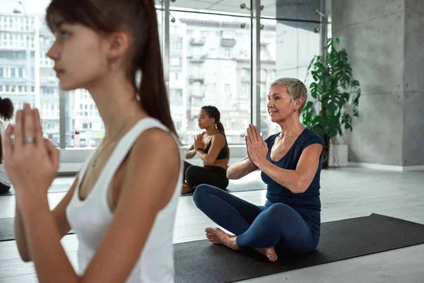 Mutlu orta yaşlı kadın grup sınıfında yoga yapıyor. — Stok fotoğraf