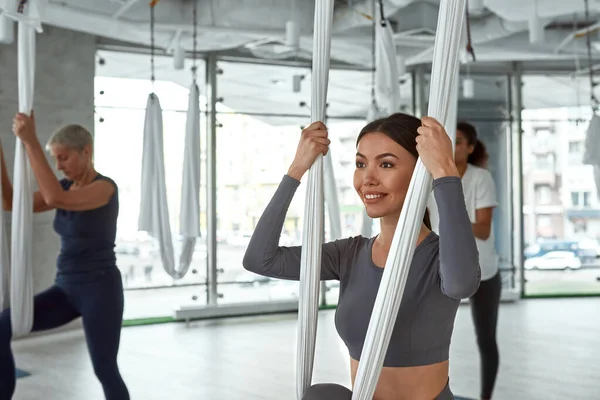 Usmívající se aktivní různorodé ženy létají jógu na tréninku — Stock fotografie