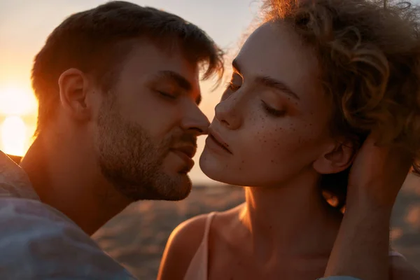 Portrait de jeunes amoureux passionnés, s'embrassant sur la plage au coucher du soleil — Photo
