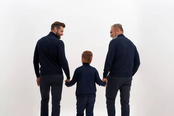Вид ззаду трьох поколінь чоловіків, що ходять разом — стокове фото