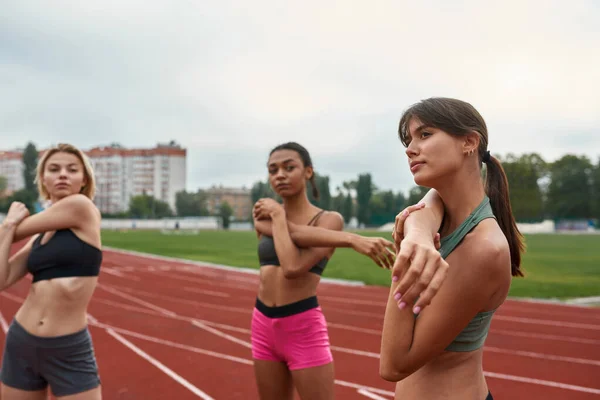 Kvinnor stretchar innan löpträning på löpband — Stockfoto