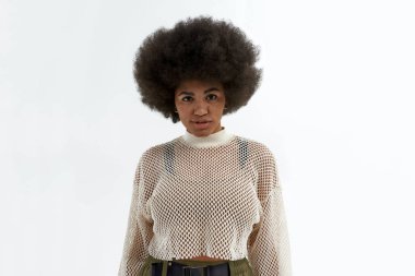 Genç, ciddi, siyah kadın kameraya bakıyor.