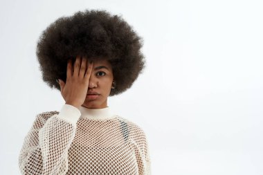 Genç siyahi kadın elleriyle gözlerini kapatıyor.