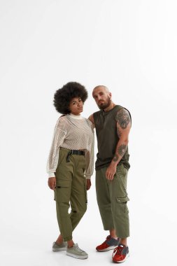 Genç beyaz adam siyah kız arkadaşına sarılıyor.