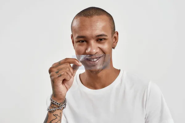 Verspielter Mischling mit blauem Film vor dem Mund, lächelnd in die Kamera, isoliert posierend vor weißem Hintergrund — Stockfoto
