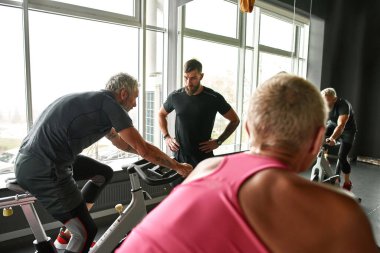 Spor salonunda bisiklete binen iki son sınıf öğrencisi