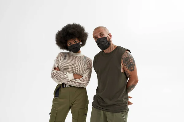 Caucásico hombre y negro mujer en máscaras médicas —  Fotos de Stock