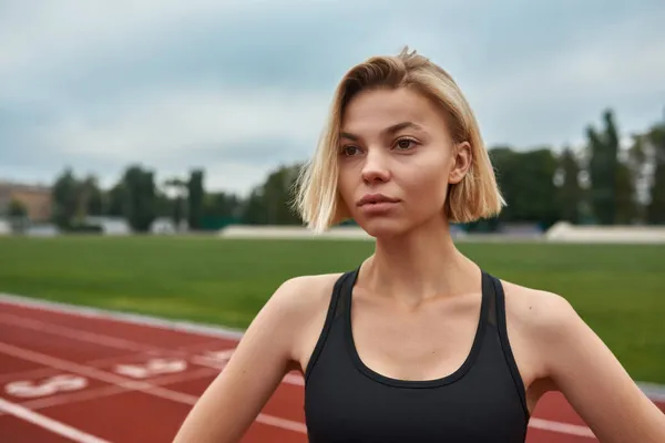 Ung europeisk idrottskvinna på stadion löpband — Stockfoto