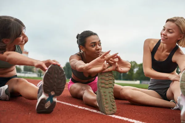 Grupp av sport flickor stretch på stadion löpband — Stockfoto