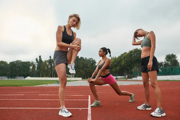 Grupp av unga idrottskvinnor stretchar på löpband — Stockfoto
