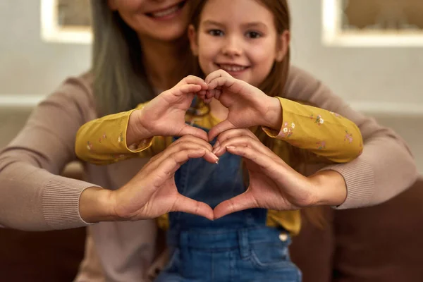 Женщина и девочка показывают знак сердца вместе — стоковое фото