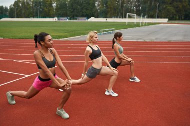 Koşu bandında gerinen bir grup çok ırklı kız.