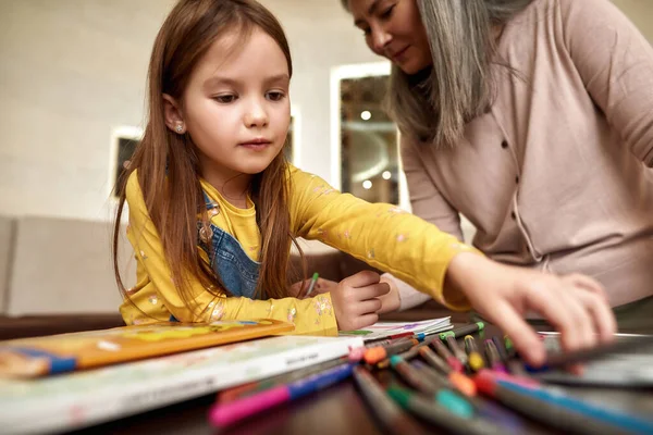 Nonna con bambina che disegna a casa — Foto Stock
