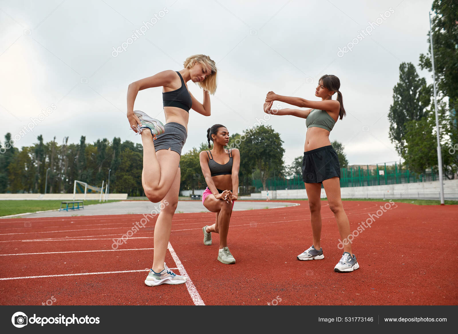 Jovenes deportes multirraciales mujeres se extienden en el estadio Foto de stock 531773146 LanaStock