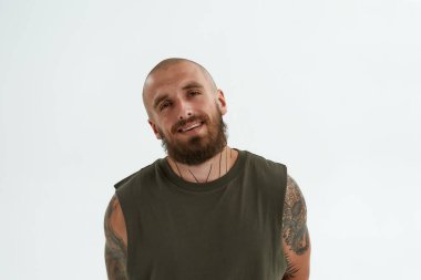 Genç, beyaz, havalı adam kameraya bakıyor.