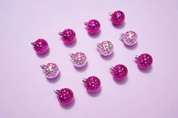 Bolas de Natal rosa em linha no fundo roxo — Fotografia de Stock