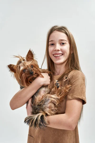 Дівчинка тримає та обіймає йоркширського собаку - тер "єра — стокове фото