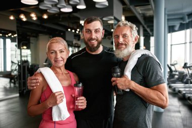 Spor salonunda yaşlı bir çiftle tatminkar antrenör.