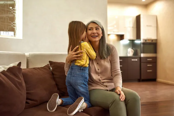 Klein meisje discreet vertellen oma haar geheim — Stockfoto