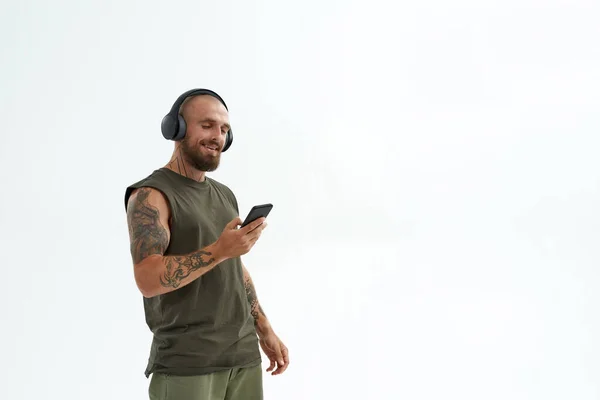 Hombre escuchando música en auriculares en el teléfono móvil —  Fotos de Stock