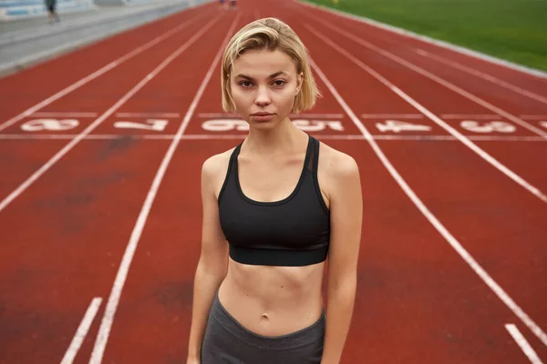 Ung kaukasisk idrottskvinna på stadion löpband — Stockfoto