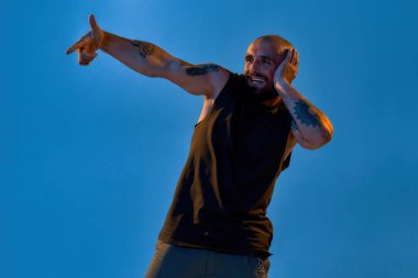 El kol hareketi yapan ve başka tarafa bakan adam.