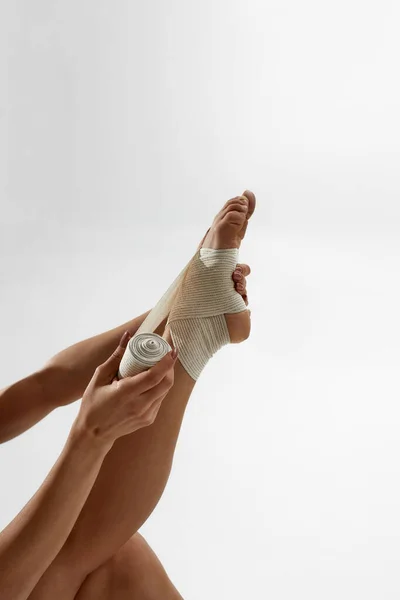 Cortado de bailarino colocando bandagem elástica na perna — Fotografia de Stock