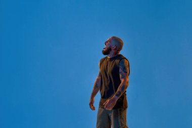 Sinirli adam dilini çıkarıp başka tarafa bakıyor.