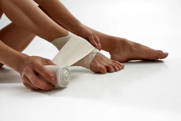 Обрізана жінка кладе еластичну пов'язку на ногу — стокове фото