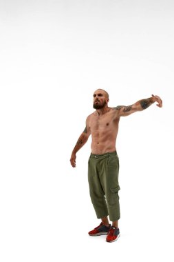 Havalı adam elinde jestler yapıyor ve başka tarafa bakıyor.