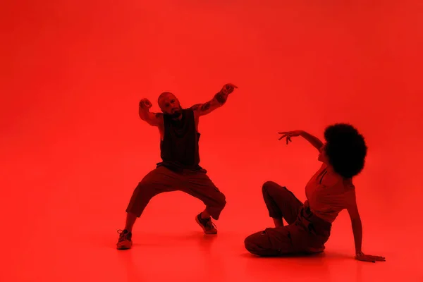 Cool pár tanec hip hop na červeném pozadí — Stock fotografie