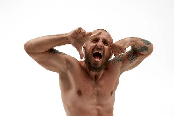 Mladý podrážděný evropský muž show biceps svaly — Stock fotografie