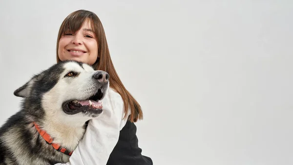 Χαμογελώντας καυκάσιος κορίτσι αγκαλιάζει Σιβηρίας Husky σκυλί — Φωτογραφία Αρχείου
