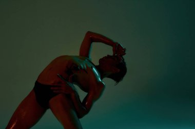 İç çamaşırlı genç erkek dansçı bale yapıyor.