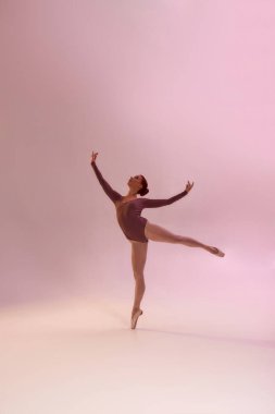 Pembe arka planda bale yapan kadın.