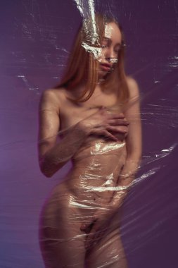 Plastik bez arkasında cinsel vücudu örten bir kız