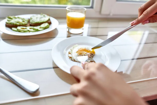 Vágott kép egy nőről, aki tükörtojást eszik reggelinél — Stock Fotó