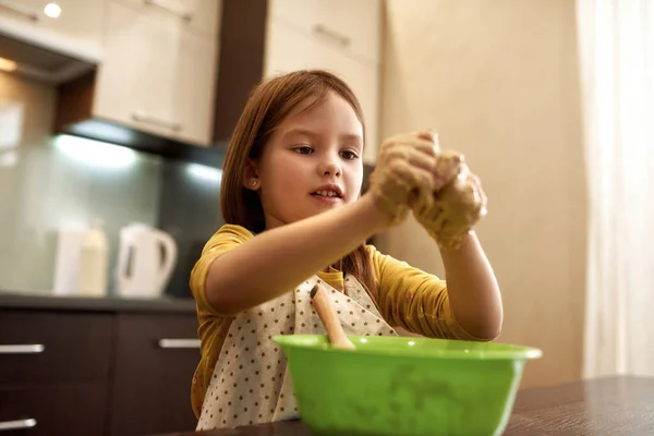 Kleines fokussiertes Mädchen blickt auf Hände mit Teig — Stockfoto