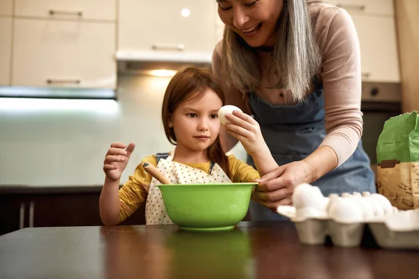 Yemek yaparken sarılıp yumurta yiyen bir kız. — Stok fotoğraf