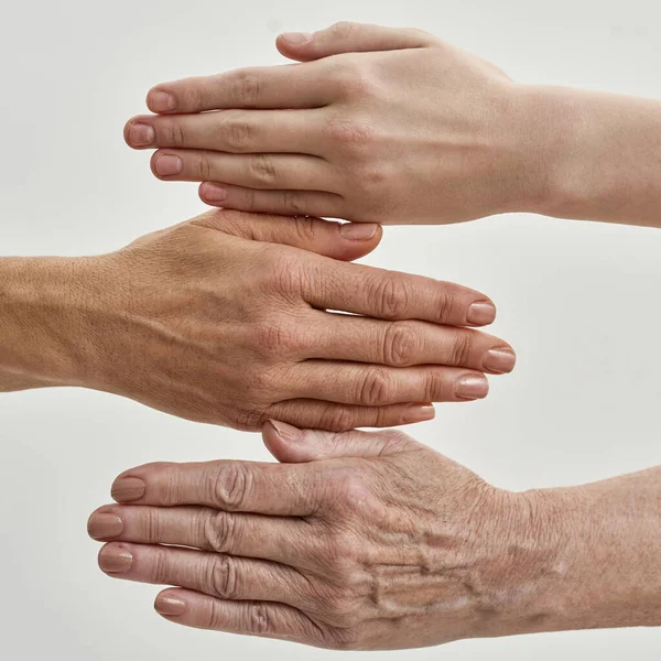 La abuela la mano entre las manos de la madre y la niña — Foto de Stock