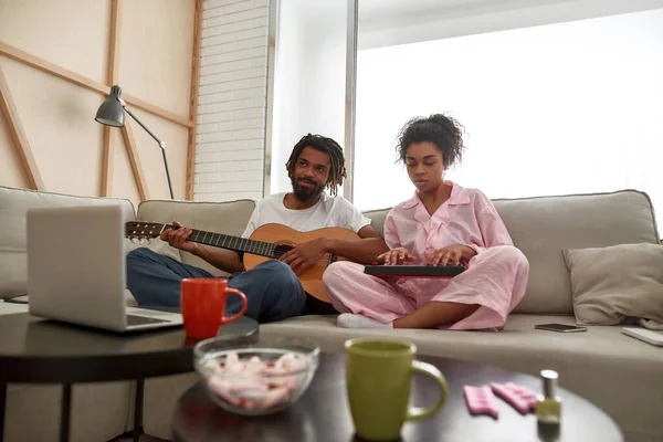 Coppia che suona musica insieme sul divano di casa — Foto Stock