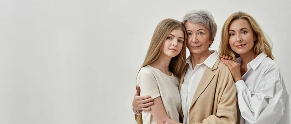 Three females hug each other and look at camera — Stock Photo, Image