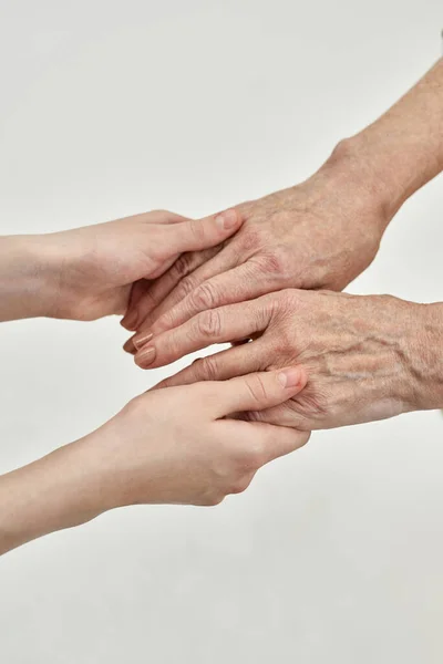Обрезанные бабушка и внучка держатся за руки — стоковое фото