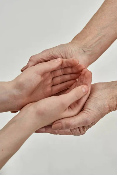 Обрезанные руки девушки в руках ее бабушки — стоковое фото