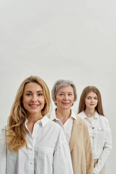 Mulheres caucasianas sorridentes olhando para a câmera em fileira — Fotografia de Stock